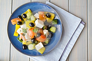 Greek salad of organic vegetables with tomatoes, cucumber, red onion, olives and feta cheese. Flat lay