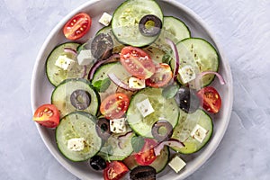 Greek salad, an overhead closeup photo. Fresh salad with feta, tomatoes, cucumbers, onions and olives