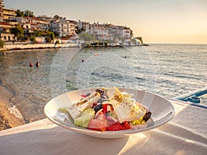 Greek Salad in sunset light at a tavern in Skala Marion town, Thasos Island, Greece