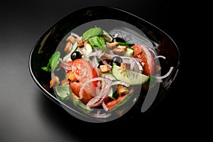 Greek salad of tomato, cucumber, chopped onion,bread croutons, and black olives