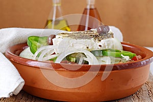 Greek salad with tomato, onion, cucumber, sweet paprika, feta cheese , oregano, vinigar, olive oil and olives.