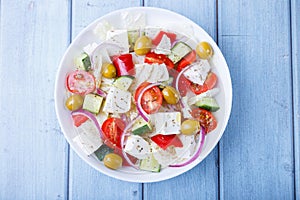 Greek salad. Traditional Greek dish. Healthy vegetarian food. Fresh vegetables and feta cheese in a white plate.