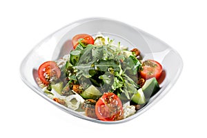 Greek salad. Vegetable with arugula leaves, green salad, with cherry tomatoes, fetta cheese, red onion, and mixed greens photo