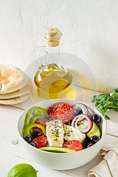 Greek salad on a white wooden background. Tomatoes, peppers, olives, cheese, onions. Healthy eating. Diet. Vegetarian food