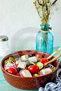 Greek salad on a wooden background. Tomatoes, peppers, olives, cheese, onions. Healthy eating. Diet. Vegetarian food