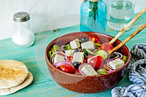 Greek salad on a wooden background. Tomatoes, peppers, olives, cheese, onions. Healthy eating. Diet. Vegetarian food