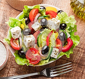 Greek salad on wooden table served and ready to eat photo