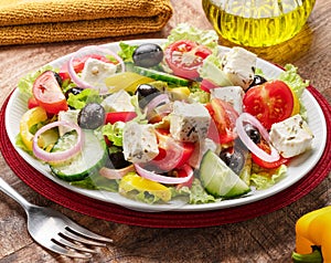 Greek salad on wooden table served and ready to eat photo