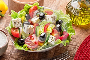 Greek salad on wooden table served and ready to eat photo