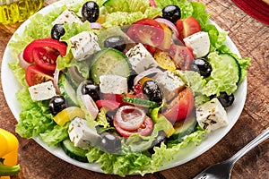 Greek salad on wooden table served and ready to eat photo