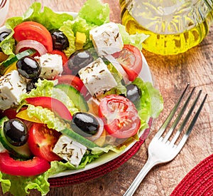 Greek salad on wooden table served and ready to eat photo