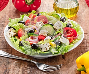 Greek salad on wooden table served and ready to eat photo