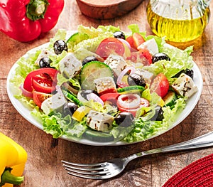 Greek salad on wooden table served and ready to eat photo