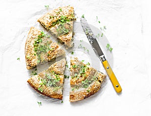 Greek spinach fresh ricotta puff pastry pie on a light background, top. Spanakopita pie