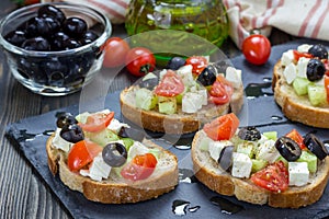 Greek style crostini with feta cheese, tomatoes, cucumber, olives, herbs