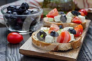Greek style crostini with feta cheese, tomatoes, cucumber, olives, herbs