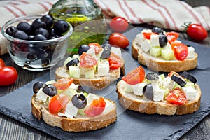 Greek style crostini with feta cheese, tomatoes, cucumber, olives, herbs