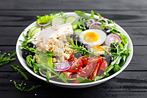 Greek style healthy lunch bowl with oatmeal, boiled egg and fresh vegetable salad with feta cheese