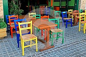 greek tavern with wood table and multicolored chairs,Crete, Greece