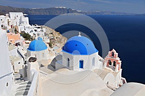 Greek white churchs with blue domes overlooking the sea, Oia, Santorini, Cyclades Islands, Greece