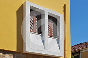 Greek window with wooden shutters.