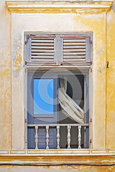 Greek window with wooden shutters.
