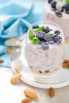 Greek yogurt or blueberry parfait with fresh berries and almond nuts on white background