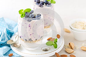 Greek yogurt or blueberry parfait with fresh berries and almond nuts on white background