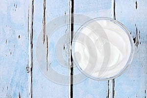 Greek yogurt, downward view on rustic blue wood photo