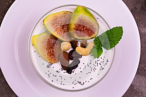 Greek yogurt with figs, nuts and honey in a bowl. Close-up. View from above.