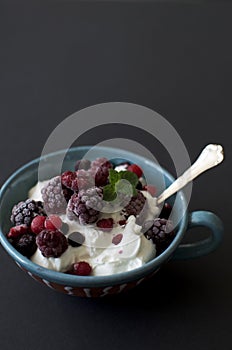 Greek yogurt with mix berries-black background