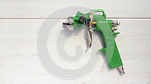 Green air compressor gun. Isolated on a wooden background