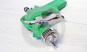 Green air compressor gun. Isolated on a wooden background