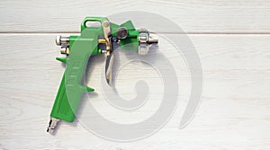 Green air compressor gun. Isolated on a wooden background