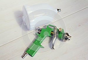 Green air compressor gun. Isolated on a wooden background