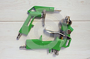 Green air compressor gun. Isolated on a wooden background