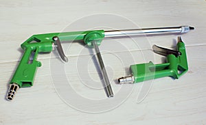 Green air compressor gun. Isolated on a wooden background