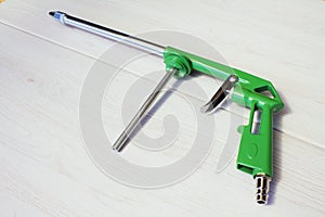 Green air compressor gun. Isolated on a wooden background