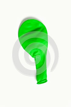 Green air deflated balloon on a white background