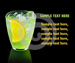 Green alcohol cocktail with lemon slice isolated on black