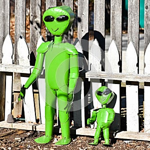 Green Alien Metal Garden Statues and Wooden Fence
