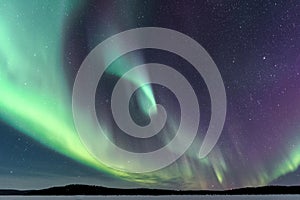 Green annd purple northern lights spiral in finnish lapland