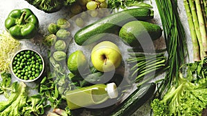 Green antioxidant organic vegetables, fruits and herbs placed on gray stone