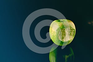 Green apple with big bite