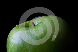 Green apple on black from side closeup