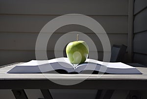 Green apple and book