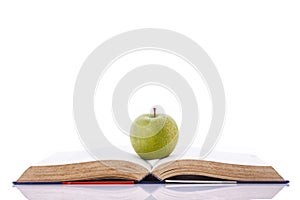 Green apple on book. Studio shot isolated on white