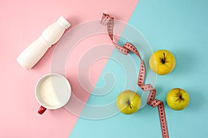 The green apple and bottle of yogurt with measure tape