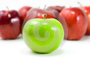 A Green Apple and a Bunch of Red Apples