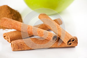 Green apple, cinnamon on white plate